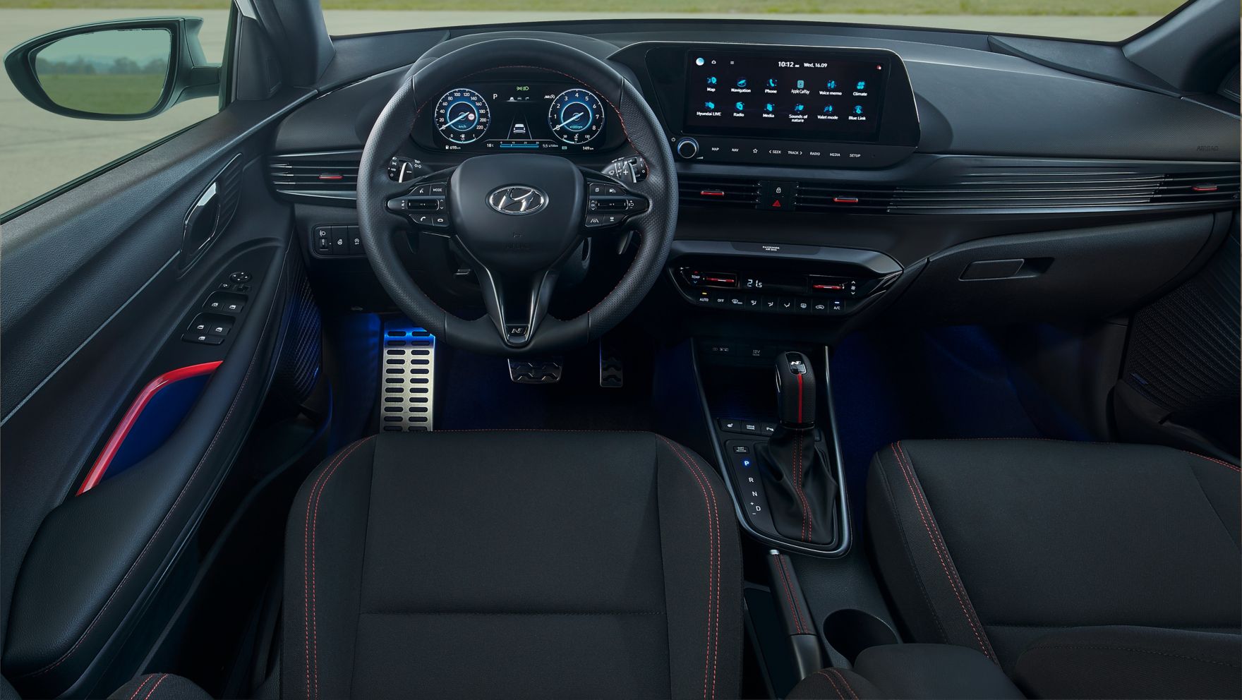 Širokoúhlý pohled na interiér nového Hyundai i20 N Line, s viditelnými rudými zvýrazněními.